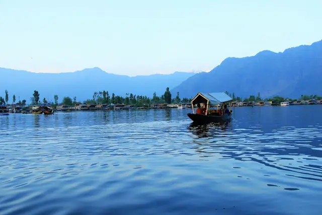 A shikara crossing the calm water of Dal Lake