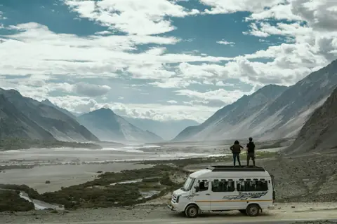 Travellers on a van roof on a Ladakh mountain road Travellers on a van roof on a Ladakh mountain road